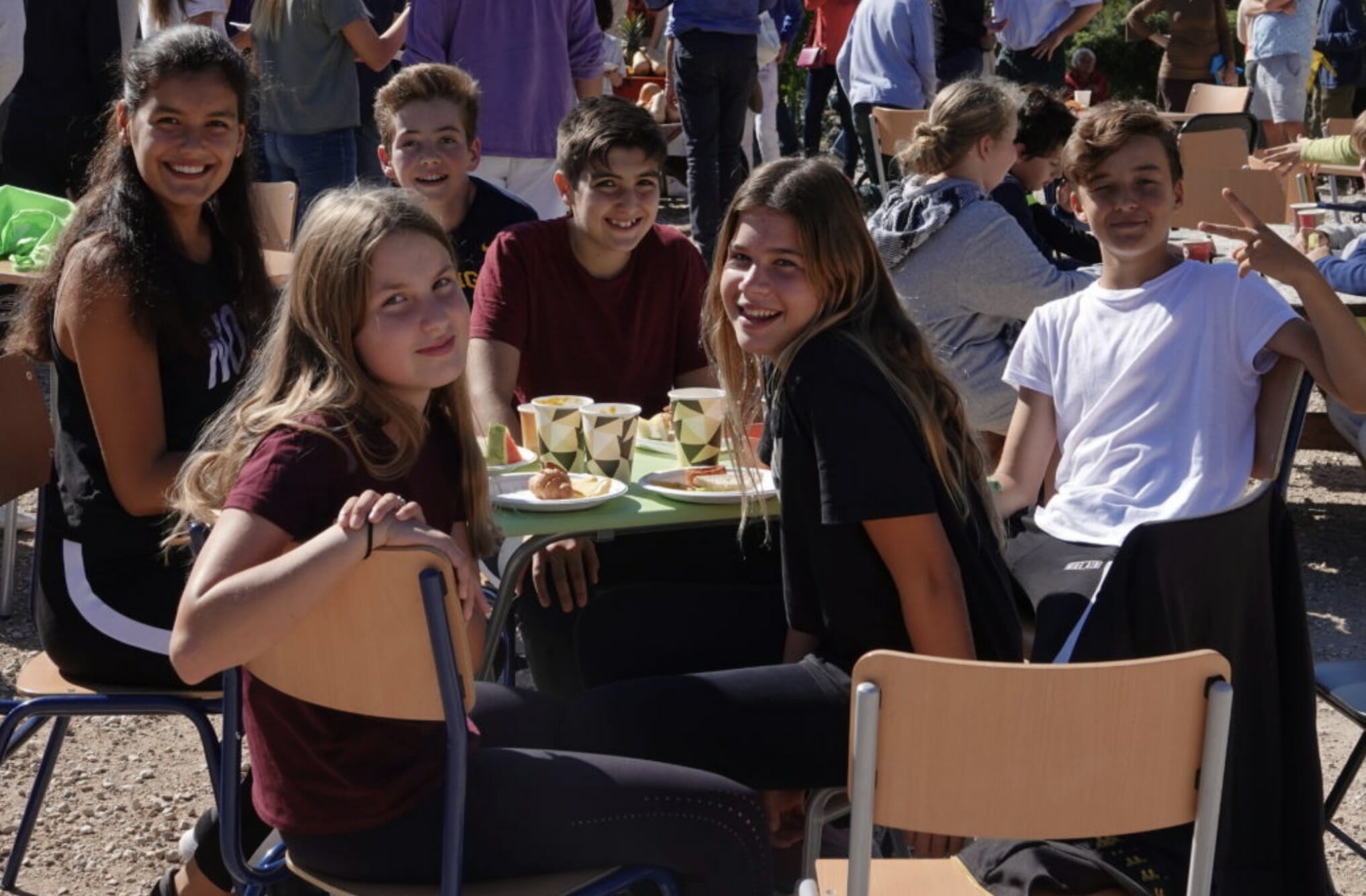 Happy AIS students having lunch at an outdoor school community event